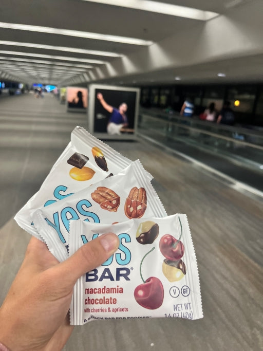 YES Bar Macadamia Chocolate bar with cherries and apricots displayed at T3, San Francisco International Airport.